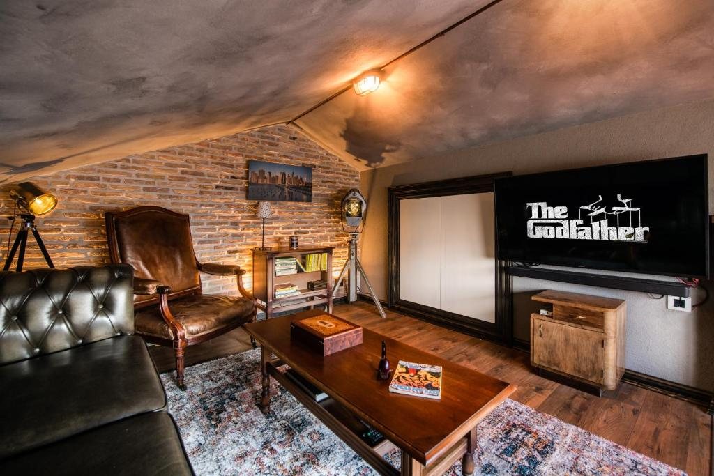 Salon s kožnim sofama i velikim televizorom