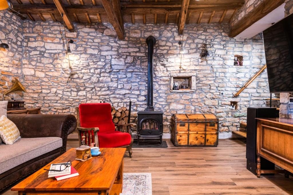Salon s peći na drva uz kameni zid